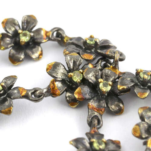 DAINTY FLORAL BRACELET IN GUNMETAL STERLING SILVER WITH PERIDOT CENTRES AND ROSE GOLD-HUED ACCENTS