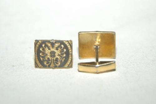 A pair of cufflinks, elegant black and gold design.