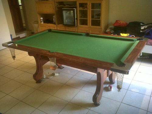 solid slate pool table with cues and balls.