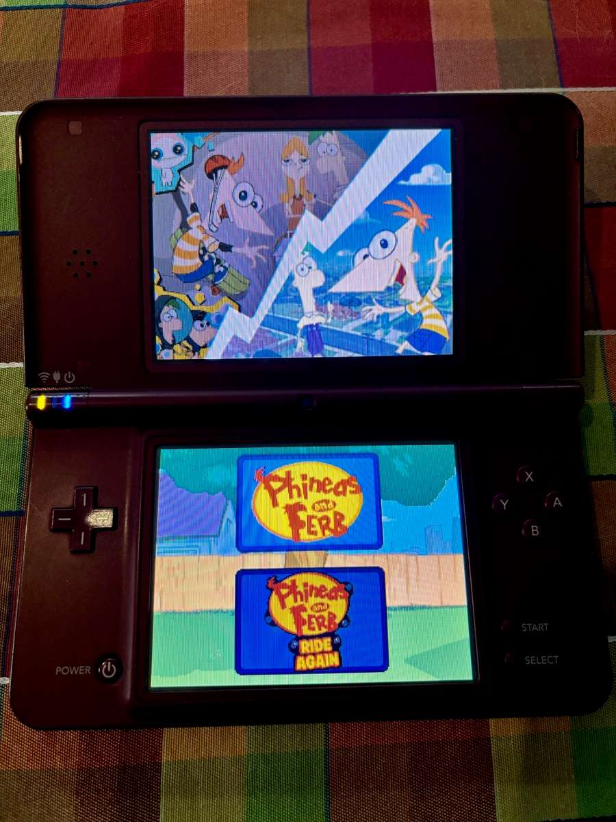 burgundy Nintendo DSi XL with charger