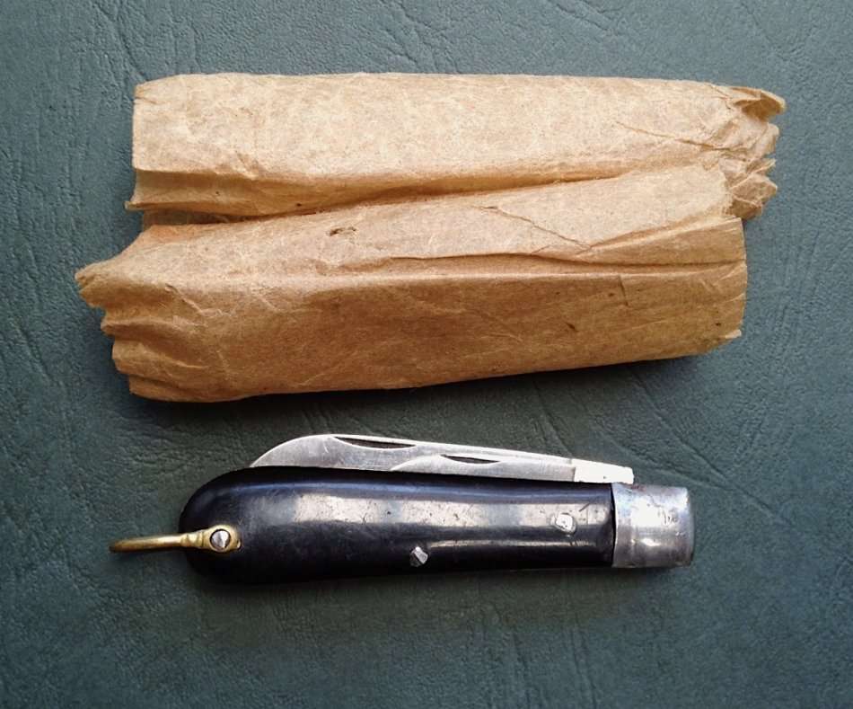 Vintage carbon steel pocket knife, unused in original brown paper wrapping.