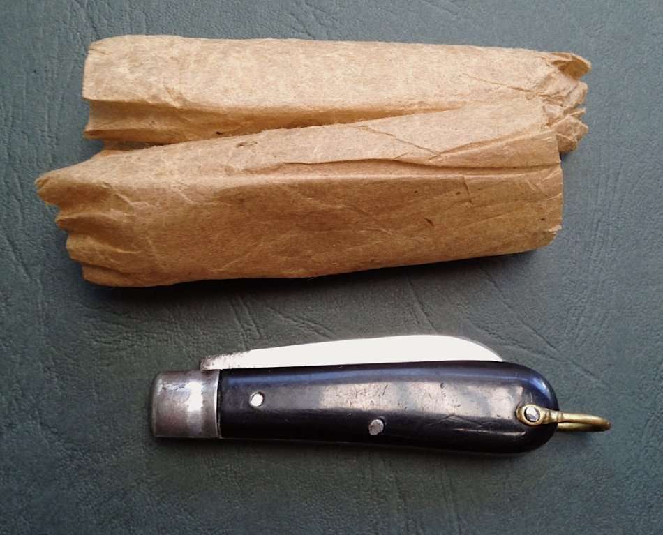 Vintage carbon steel pocket knife, unused in original brown paper wrapping.