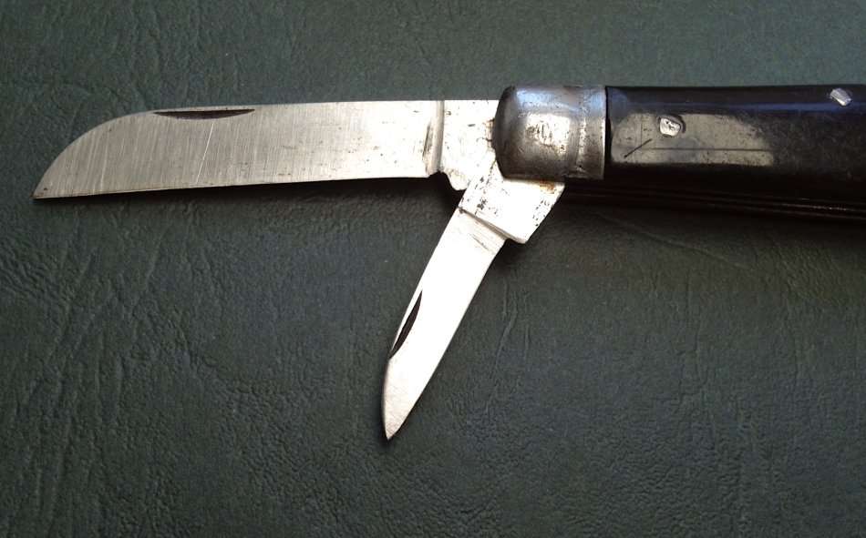 Vintage carbon steel pocket knife, unused in original brown paper wrapping.