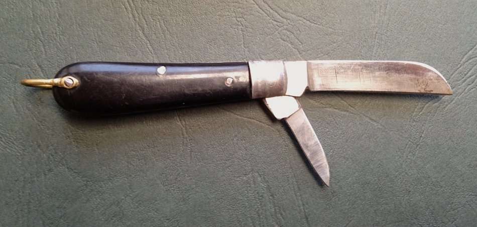 Vintage carbon steel pocket knife, unused in original brown paper wrapping.