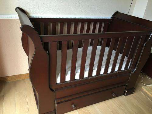 Dark wood cot with adjustable settings