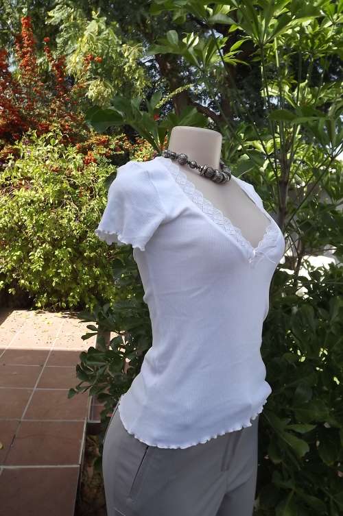 Plain white H + M stretch ribbed short sleeve top.Size 32/8.Low laced V neck.As new.