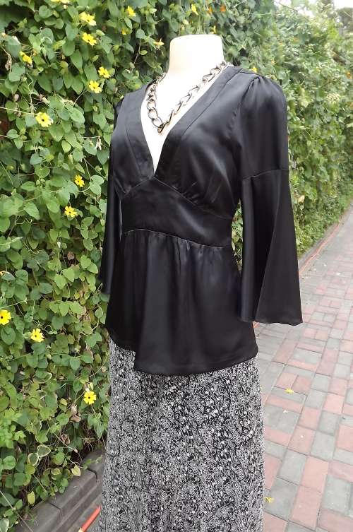 Black silky satin look top with flare sleeve cuffs.Size 32/8 by RT. V neck.Sexy open back