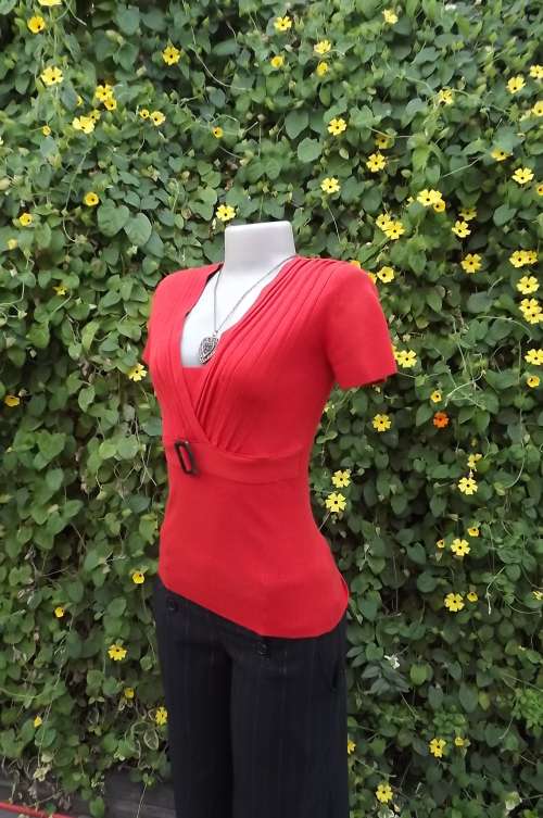 Nectarine colour knitted V neck Truworths top in size 32/8.Permanent pleats on front with buckle