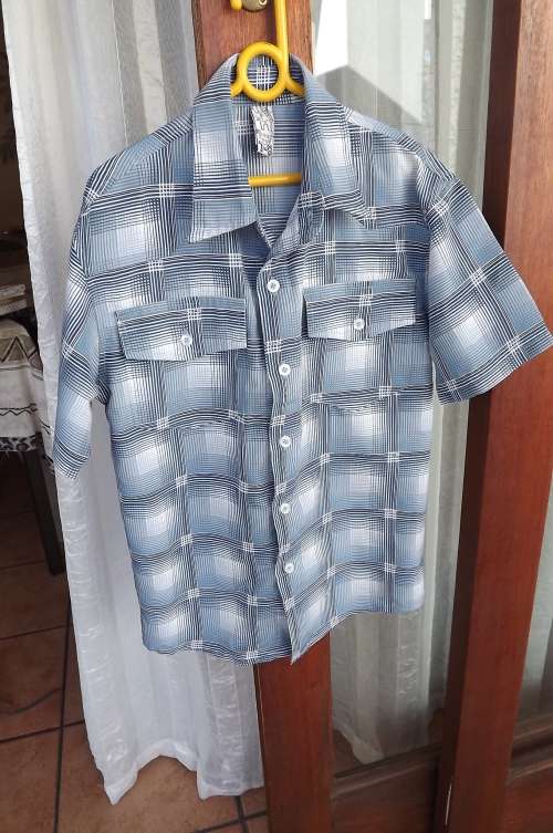 Pretty blue checked short sleeve shirt by RT for 7 to 8 year old boy.With 2 front pockets.