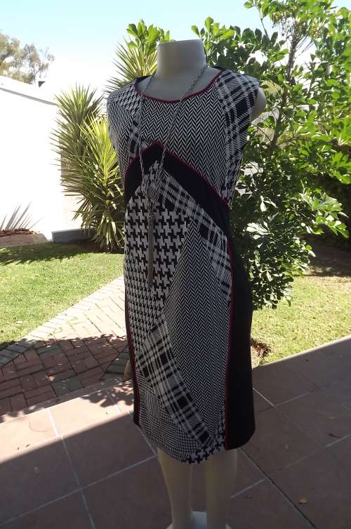 Black sleeveless size 42/18 dress by Judy's Pride.In jersy fabric with checked front and red edging