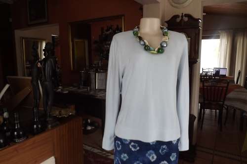 Soft baby blue V neck acrylic knit long sleeve top in size 36/12.Two short slits at sides.