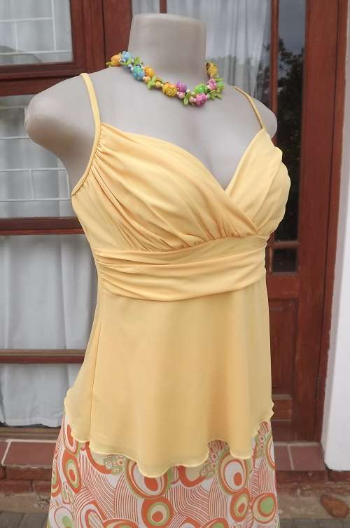 Sexy buttercup yellow sheer polyester strappy top.Size 34/10.Empire waist .As new