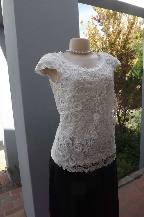 Flirty feminine lace top in size 34/10.Over nylon underlay and back.Tiny cap sleeves by COOL ICE.