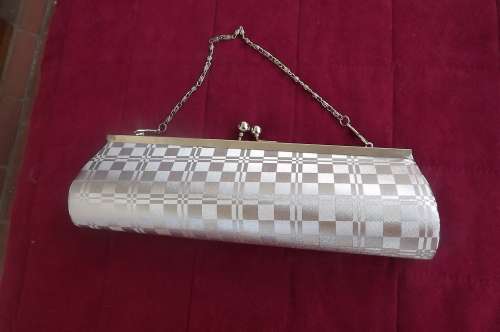 Silver evening bag in check pattern.Size 25.5 x 8.5 cm.Close with clip.Chain handle.New condition.