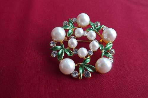 Beautiful new brooch with leafs in green enamel.round with display of faux pearls.Diameter 5cm
