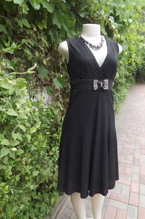 Pretty black stretch polyester fully lined dress with tiny white polka dots.Size 32/8.See scans