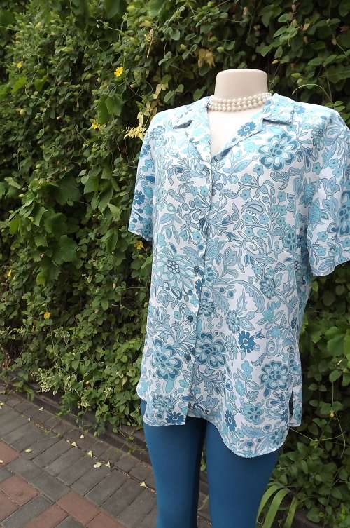 Beautiful white and blue floral short sleeve blouse in 100% wash + wear polyester.Size 40/16