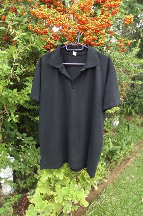 Black men's golf shirt in new condition in size Large 100% cotton fabric.