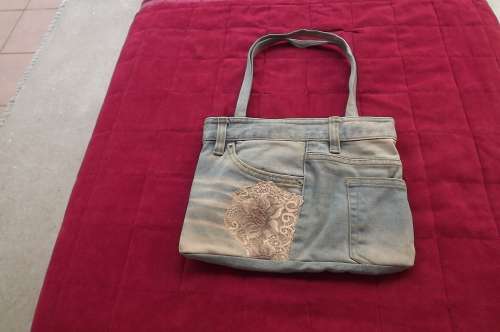 Modern light blue denim handbag made from worn jeans.With lace decoration on side.Size 21 x28cm.New