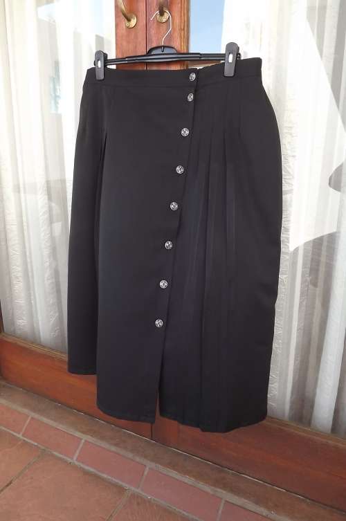 Black skirt in size 46/22.Button down at left front.Three pleats at each front.