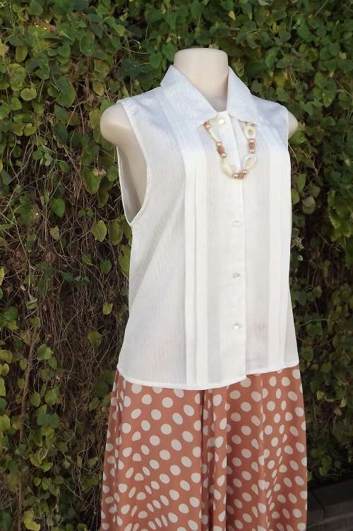 Go feminine with a nostalgic sleeveless white textured 100% polyester blouse.Size 36/12. As new