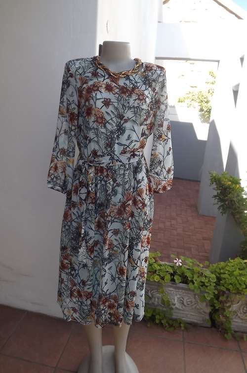 Top of the line sheer polyester dress in pale blue,brown,mustard and navy floral pattern.