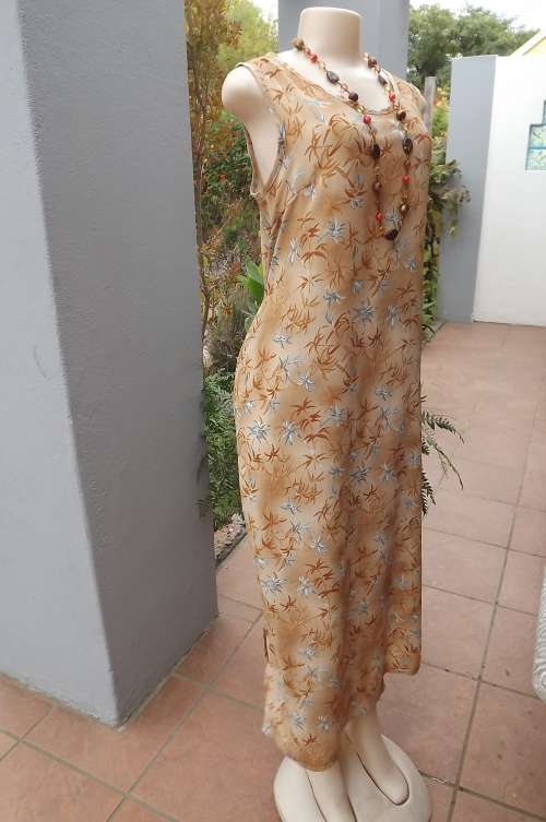 Maxi dress in 100% textured polyester in blue & tan leafs on beige black ground.Size 36/12.By SCOTTS