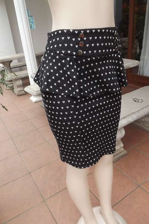 Smart playfull black peplum skirt in size 34/10 by W.W.W.with tiny white hearts.New condition