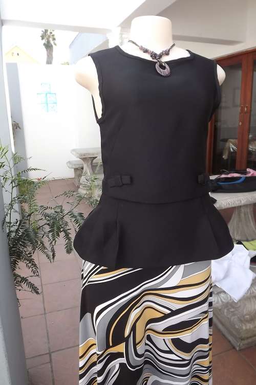 Black sleeveless peplum top in size 30/6.Long zip at back.In heavy 100% polyester.New top.