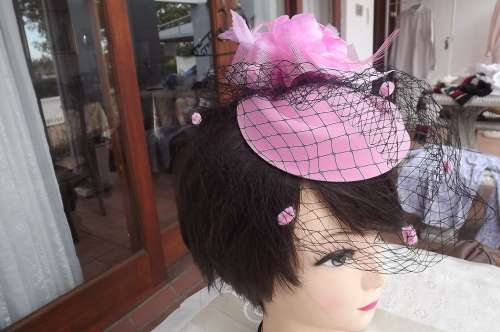 Beautiful pink pillbox style facinator with flower and black netting.New.