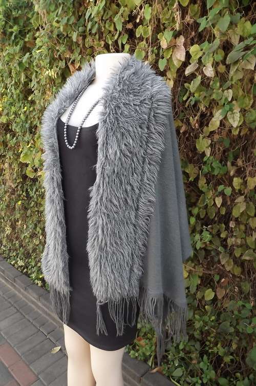 Grey stole in knitted fabric with grey faux fur around seam and frilled sides.Size 65cm x 165cm
