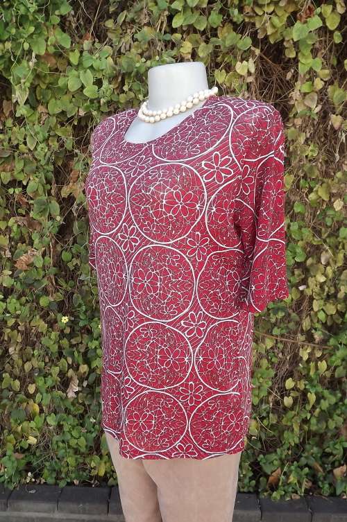 Pretty red circle patterned pull over short sleeve top with white floral pattern.Size 40/16