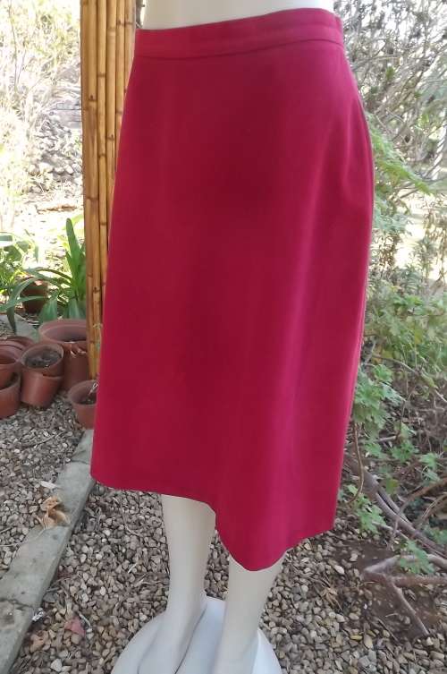 Dark pink a line skirt in ribbed polyester fabric.Calflength with zip at back.Size 36/12