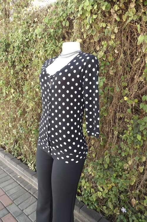 Black knitted cardigan with white polkadots.In 100% polyester by RT in size 32/8.