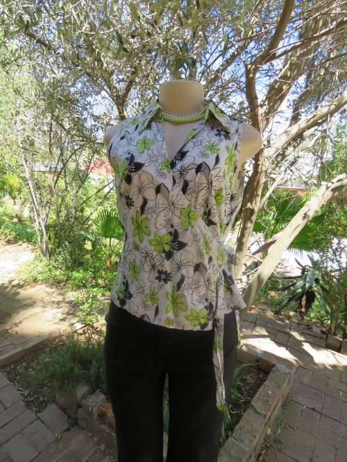 Fashionable white cross over sleeveless top by HOT TOPIC with tie in middle.Size 38/14