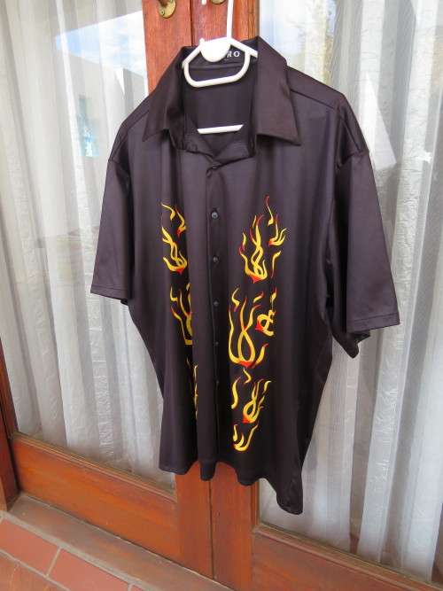 Silky black polyester short sleeve shirt by AERO.Size L.Chest 124cm with flame design on front.