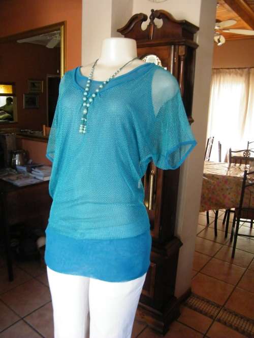 Pretty turquoise top in 2 layers.Top layer in nylon mesh.Size 34/10.Short cut-on sleeves.