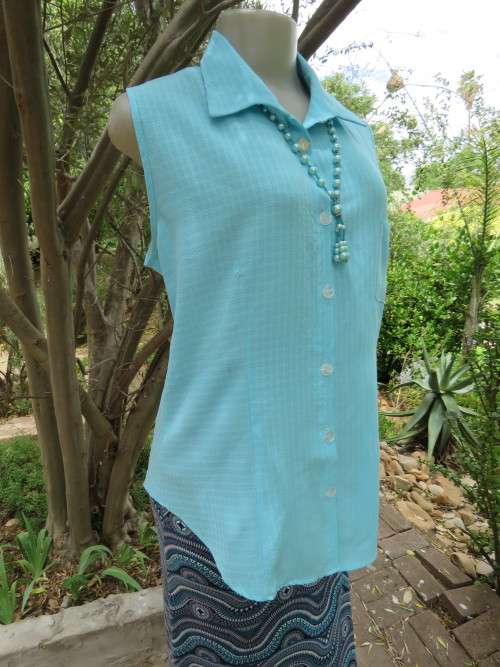 Cool sky blue sleeveless top with button down front and open collar.Size 39/15
