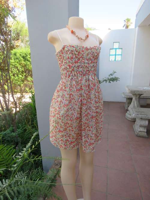White floral mini dress with pink and blue flowers. Elasticated top with adjustable straps.Size 32/8