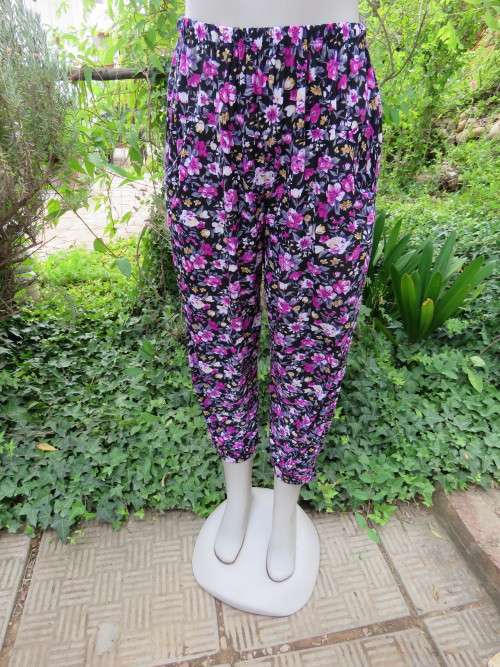 Black stretch polyester pants with purple,white and cream floral pattern.Size 36/12 .