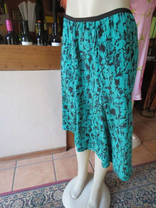Attractive half flare panelled skirt in silky polyester with elasticated waist.Size 42/18.Good cond.