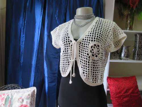 Off-white crochet bolero done in cotton yarn with tiny capped sleeves.Size 36/12.Used condition.