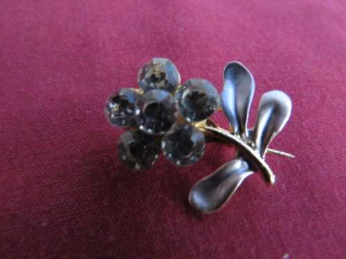 Tiny little brooch with 3 silver and cream enamel leaves and 6 faux diamond stones.New.