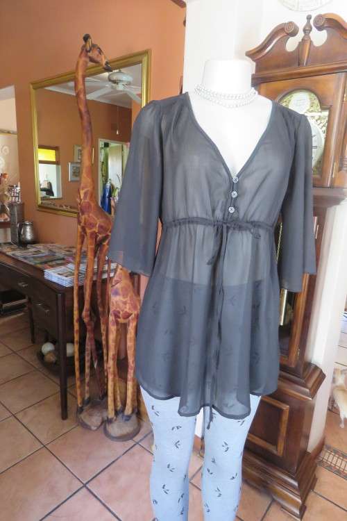 Delightful sheer black top with empire waist and tiestring. Low V closing with 3 buttons on Front.