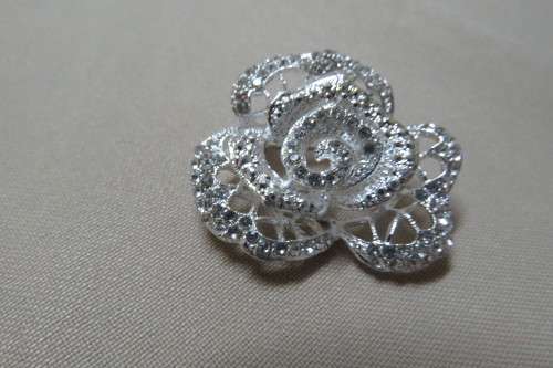 Beautiful silver toned brooch in rose pattern with tiny little shiny stones. New.