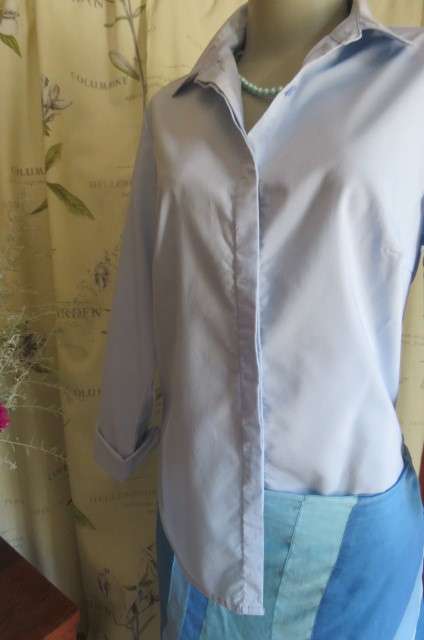 Styled powder blue long sleeve top by 'Fix'in size 36/12. Hidden button down front with shirt collar