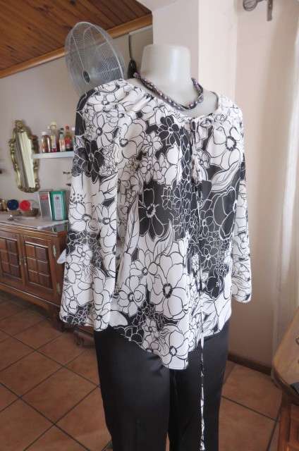 Black and white top with bold floral pattern With raglan sleeves in bracelet length Size 32/8.As new
