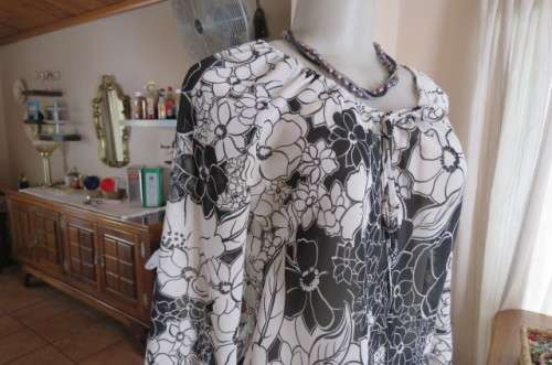 Black and white top with bold floral pattern With raglan sleeves in bracelet length Size 32/8.As new