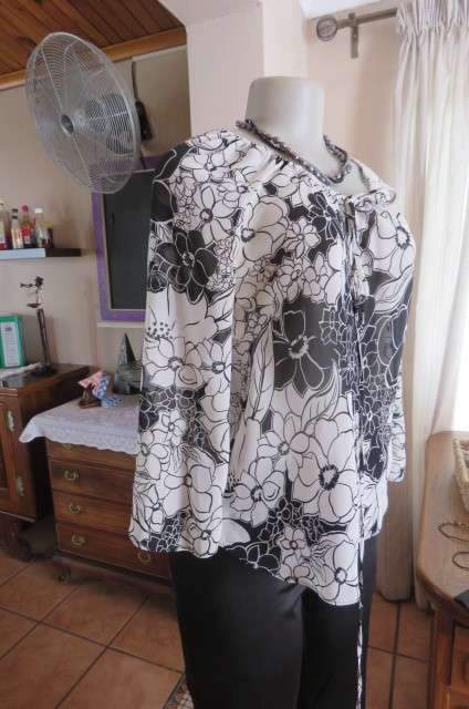 Black and white top with bold floral pattern With raglan sleeves in bracelet length Size 32/8.As new