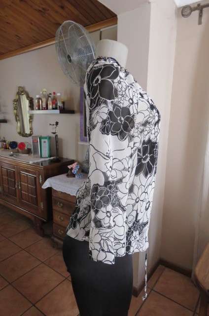 Black and white top with bold floral pattern With raglan sleeves in bracelet length Size 32/8.As new